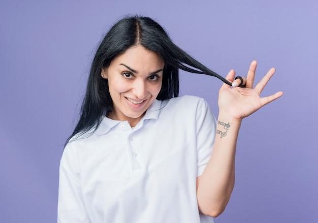 Cheerful woman showing OK sign while holding her hair